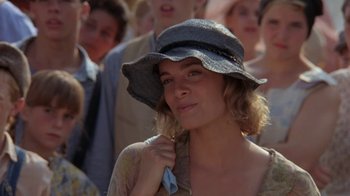 Movie still from “Wild Hearts Can't Be Broken” (1991), directed by Steve Miner – A person wearing a hat with people in the background; Close Up shot, Over the shoulder angle