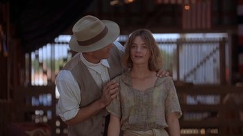 Movie still from “Wild Hearts Can't Be Broken” (1991), directed by Steve Miner – A man standing next to a woman wearing a hat; Medium shot, Low angle