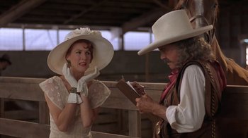 Movie still from “Wild Hearts Can't Be Broken” (1991), directed by Steve Miner – A woman in a white dress and a man in a white hat; Medium shot, Over the shoulder angle