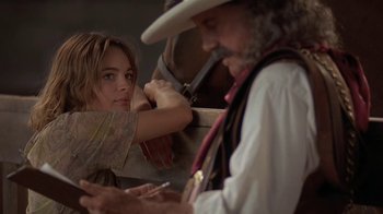 Movie still from “Wild Hearts Can't Be Broken” (1991), directed by Steve Miner – A woman looking at a man in a cowboy hat; Close Up shot, Over the shoulder angle