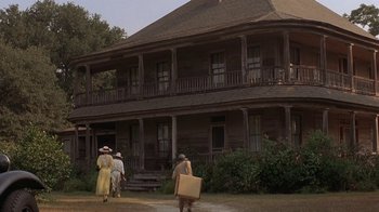 Movie still from “Wild Hearts Can't Be Broken” (1991), directed by Steve Miner – A group of people walking in front of an old house; Extreme Wide shot, Low angle