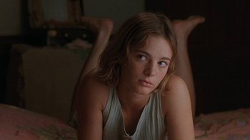 Movie still from “Wild Hearts Can't Be Broken” (1991), directed by Steve Miner – A woman sitting on the ground looking at the camera; Close Up shot, Over the shoulder angle