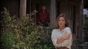 Movie still from “Wild Hearts Can't Be Broken” (1991), directed by Steve Miner – A woman standing in front of a man in front of a house; Medium shot, Over the shoulder angle
