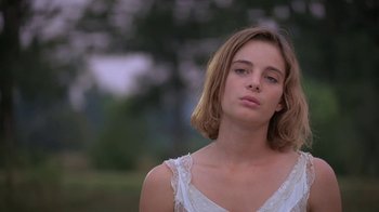 Movie still from “Wild Hearts Can't Be Broken” (1991), directed by Steve Miner – A young woman in a white dress looking to her left; Close Up shot, Low angle