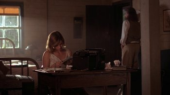 Movie still from “Wild Hearts Can't Be Broken” (1991), directed by Steve Miner – A woman sitting at a table looking at papers; Wide shot, Low angle