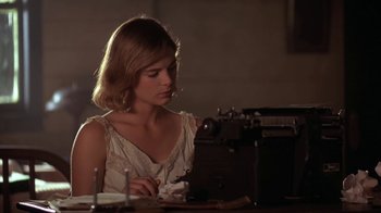 Movie still from “Wild Hearts Can't Be Broken” (1991), directed by Steve Miner – A woman sitting in front of an old fashioned typewriter; Medium shot, Low angle