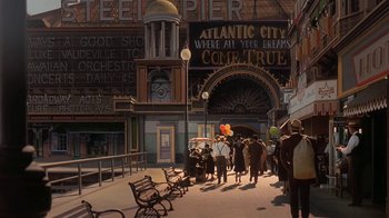 Movie still from “Wild Hearts Can't Be Broken” (1991), directed by Steve Miner – A group of people walking down a street near a building; Wide shot, High angle