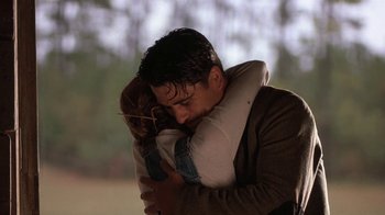 Movie still from “Wild Hearts Can't Be Broken” (1991), directed by Steve Miner – A man and a woman hugging each other in a field; Medium shot, Low angle