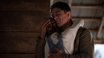 Movie still from “Wild Hearts Can't Be Broken” (1991), directed by Steve Miner – A young man holding a young girl in his arms; Medium shot, Low angle