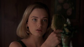 Movie still from “Wild Hearts Can't Be Broken” (1991), directed by Steve Miner – A woman holding a brush in front of a mirror; Close Up shot, Low angle