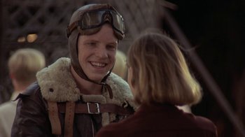 Movie still from “Wild Hearts Can't Be Broken” (1991), directed by Steve Miner – A man wearing a pilot's outfit and a helmet talking to a woman; Close Up shot, Over the shoulder angle