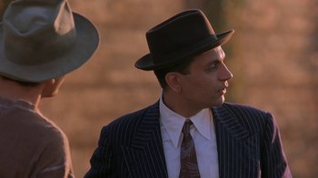 Movie still from “Wild Hearts Can't Be Broken” (1991), directed by Steve Miner – A man in a suit and hat looking to his left; Close Up shot, Low angle