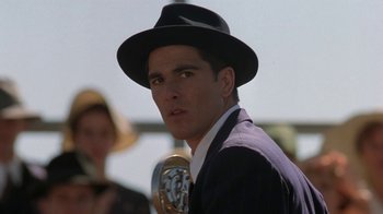 Movie still from “Wild Hearts Can't Be Broken” (1991), directed by Steve Miner – A man wearing a hat and a suit and tie; Close Up shot, Low angle