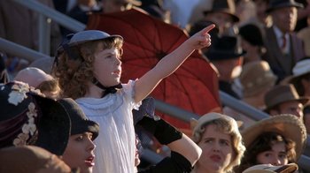 Movie still from “Wild Hearts Can't Be Broken” (1991), directed by Steve Miner – A young girl points at something while standing in a crowd of people; Close Up shot, Low angle