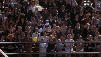 Movie still from “Wild Hearts Can't Be Broken” (1991), directed by Steve Miner – A group of people sitting in the stands at a sporting event; Wide shot, High angle