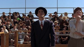 Movie still from “Wild Hearts Can't Be Broken” (1991), directed by Steve Miner – A man in a suit and hat standing in front of a crowd; Medium shot, Low angle