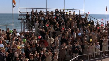 Movie still from “Wild Hearts Can't Be Broken” (1991), directed by Steve Miner – A crowd of people standing on top of bleachers at an event; Extreme Wide shot, High angle