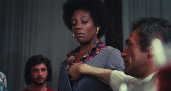 Movie still from “Your Vice Is a Locked Room and Only I Have the Key” (1972), directed by Sergio Martino – An african american woman is being held by a man; Medium shot, Low angle