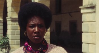 Movie still from “Your Vice Is a Locked Room and Only I Have the Key” (1972), directed by Sergio Martino – An older woman with afro hair wearing a sweater; Close Up shot, Low angle