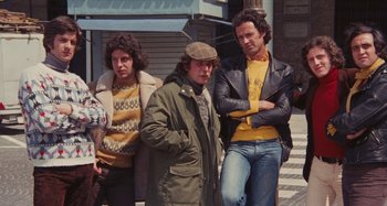 Movie still from “Your Vice Is a Locked Room and Only I Have the Key” (1972), directed by Sergio Martino – A group of people standing next to each other on the sidewalk; Medium shot, High angle