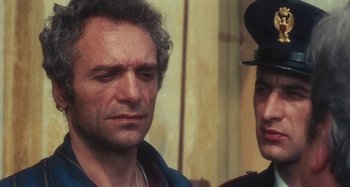 Movie still from “Your Vice Is a Locked Room and Only I Have the Key” (1972), directed by Sergio Martino – A man standing next to a woman in a hat; Close Up shot, Over the shoulder angle