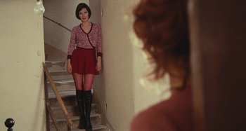 Movie still from “Your Vice Is a Locked Room and Only I Have the Key” (1972), directed by Sergio Martino – A woman in a short skirt standing on a staircase; Medium shot, Over the shoulder angle