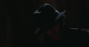 Movie still from “Your Vice Is a Locked Room and Only I Have the Key” (1972), directed by Sergio Martino – A person wearing a hat in the dark; Close Up shot, Low angle