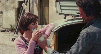 Movie still from “Your Vice Is a Locked Room and Only I Have the Key” (1972), directed by Sergio Martino – A woman is drinking from a cup while standing next to a man; Medium shot, High angle