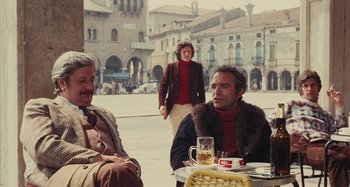 Movie still from “Your Vice Is a Locked Room and Only I Have the Key” (1972), directed by Sergio Martino – Two men and a woman sitting at an outdoor table; Medium shot, High angle