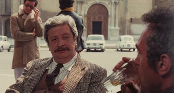 Movie still from “Your Vice Is a Locked Room and Only I Have the Key” (1972), directed by Sergio Martino – An older man wearing a suit and tie; Medium shot, Over the shoulder angle