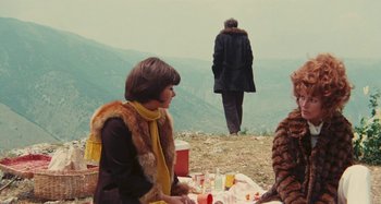 Movie still from “Your Vice Is a Locked Room and Only I Have the Key” (1972), directed by Sergio Martino – A woman sitting on a blanket on top of a hill; Wide shot, Over the shoulder angle