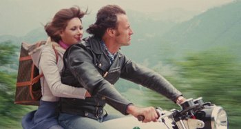 Movie still from “Your Vice Is a Locked Room and Only I Have the Key” (1972), directed by Sergio Martino – A man and a woman riding a bike together; Medium shot, Low angle