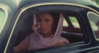 Movie still from “Your Vice Is a Locked Room and Only I Have the Key” (1972), directed by Sergio Martino – A woman in a car with a scarf around her head; Medium shot, Over the shoulder angle