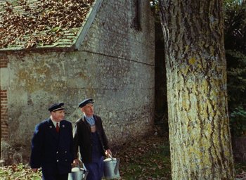 Movie still from “Ô saisons ô chateaux” (1958), directed by Agnès Varda – A couple of men walking next to a tree; Wide shot, High angle