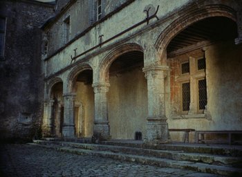 Movie still from “Ô saisons ô chateaux” (1958), directed by Agnès Varda – An image of a building with arches in the middle of the day; Extreme Wide shot, Low angle