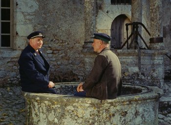 Movie still from “Ô saisons ô chateaux” (1958), directed by Agnès Varda – Two men sitting in a well talking to each other; Wide shot, High angle