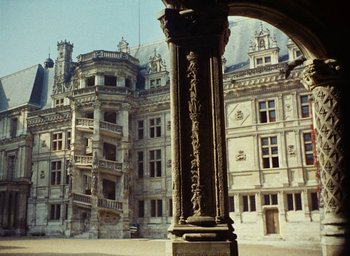 Movie still from “Ô saisons ô chateaux” (1958), directed by Agnès Varda – An old building with a very large building in the background; Extreme Wide shot, High angle