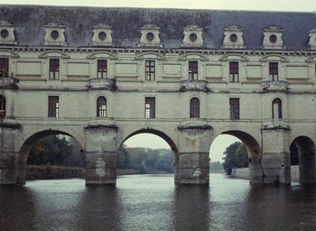 Movie still from “Ô saisons ô chateaux” (1958), directed by Agnès Varda – A building that has many windows on the side of it; Extreme Wide shot, Low angle