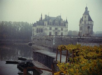 Movie still from “Ô saisons ô chateaux” (1958), directed by Agnès Varda – A large castle with a body of water in front of it; Extreme Wide shot, High angle