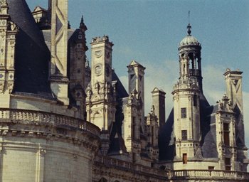 Movie still from “Ô saisons ô chateaux” (1958), directed by Agnès Varda – A group of buildings that are very tall; Extreme Wide shot, Low angle