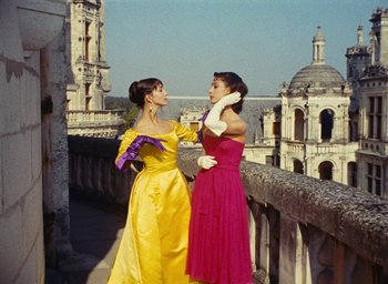 Movie still from “Ô saisons ô chateaux” (1958), directed by Agnès Varda – Two women are standing next to each other on a balcony; Medium shot, Low angle