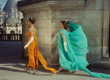 Movie still from “Ô saisons ô chateaux” (1958), directed by Agnès Varda – A couple of women walking down a street; Wide shot, Low angle
