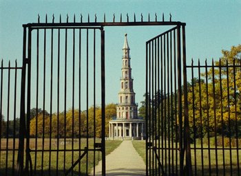 Movie still from “Ô saisons ô chateaux” (1958), directed by Agnès Varda – A gate leading into a park with a building in the background; Extreme Wide shot, Low angle