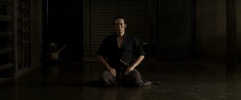 A man sitting on the ground holding a sword