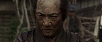 An old man with a bloody face and a black shirt