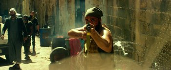 Movie still from “13 Hours” (2016), directed by Michael Bay – A man holding a camera in his hands; Medium shot, Over the shoulder angle