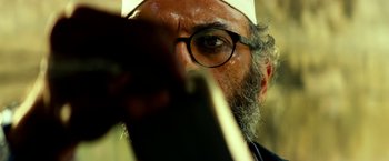 Movie still from “13 Hours” (2016), directed by Michael Bay – A man with a beard wearing glasses and a white hat; Extreme Close Up shot, Low angle