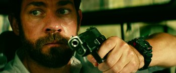 Movie still from “13 Hours” (2016), directed by Michael Bay – A person holding a gun in his hand; Close Up shot, Low angle