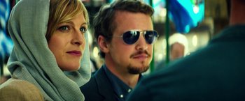 Movie still from “13 Hours” (2016), directed by Michael Bay – A man and a woman wearing sunglasses on a bus; Close Up shot, Low angle