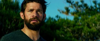 Movie still from “13 Hours” (2016), directed by Michael Bay – A person with a beard looking at the camera; Close Up shot, Low angle